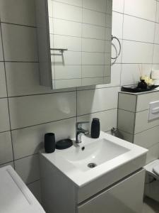 a white bathroom with a sink and a mirror at Apartment Prizren New and Modern in Prizren