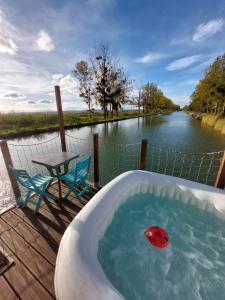 a bath tub with a red ball in the water at Cottage flottant terrasse jacuzzi option aux Portes de Dijon 