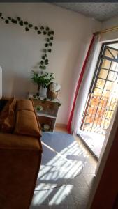 sala de estar con sofá y ventana en Lovely one bedroom airbb in THIKA with WiFi ,ample parking-next to the road, en Thika