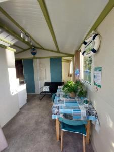 a room with a table and chairs and a couch at Cottage flottant terrasse jacuzzi option aux Portes de Dijon 