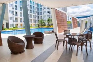 a patio with a table and chairs and a pool at SEAWIND TOWER 6 CONDOMINIUM in Davao City