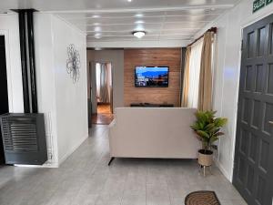 salon z białą kanapą i telewizorem w obiekcie Tierra de Canoeros w mieście Ushuaia