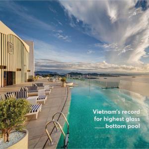 uma piscina num resort com cadeiras e o oceano em JK.Boutique Oceanfront Panorama Residence em Nha Trang