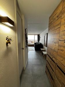 a room with a hallway with a door with a wall at Superbe studio Anzère, rénové, au pied des pistes in Anzère