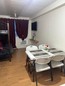 a dining room with a table and white chairs at SEAWIND TOWER 6 CONDOMINIUM in Davao City