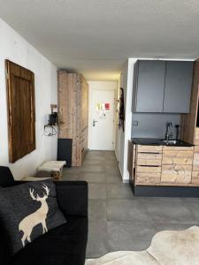 a living room with a couch and a kitchen at Superbe studio Anzère, rénové, au pied des pistes in Anzère