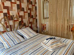 a bed with a blue and white blanket on it at Family lodg in Calais