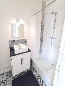 een witte badkamer met een wastafel en een douche bij Vivez Le Centre ville à la Plage - Balcon in Le Havre