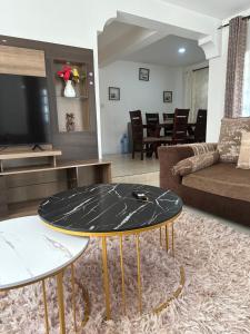 een woonkamer met een tafel en een bank bij Arlshy furnished apartments in Kisumu