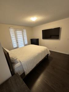 sypialnia z łóżkiem i telewizorem z płaskim ekranem w obiekcie ON Residence w mieście Hamilton