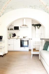 Il comprend une cuisine blanche et un salon doté d'un canapé blanc. dans l'établissement Casa Redi, à Rome