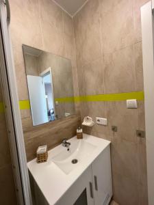 een badkamer met een wastafel en een spiegel bij Precioso Apto con vistas al Parque Nacional Doñana in Chipiona