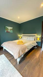 a bedroom with a large bed with green walls at Cosy cottage direct at the sea in Valentia Island