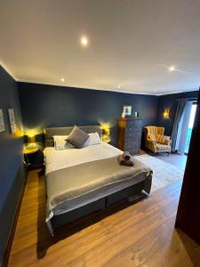 1 dormitorio con 1 cama grande y pared azul en Cosy cottage at the sea, en Isla de Valentia