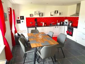 a kitchen with a wooden table and chairs at Cosy cottage direct at the sea in Valentia Island