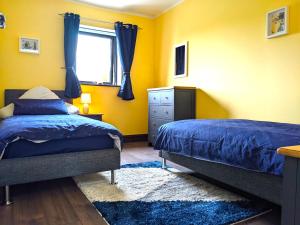 a bedroom with two beds and a window at Cosy cottage at the sea in Valentia Island