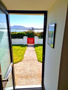 une porte donnant sur une maison avec vue sur un trottoir dans l'établissement Cosy cottage at the sea, à Île de Valentia