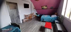 Habitación con 2 camas, mesa y sillas en Les Trois chambres de LYLY situées a Brou, en Brou