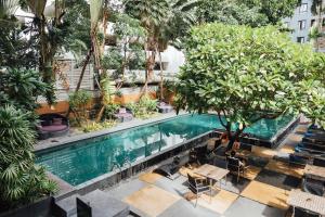 an overhead view of a pool with trees and chairs at Aspira 12th Avenue Asoke Sukhumvit in Bangkok