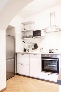 La cuisine est équipée de placards blancs et d'un réfrigérateur en acier inoxydable. dans l'établissement Casa Redi, à Rome