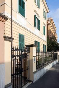 une clôture noire à côté d'un bâtiment avec volets verts dans l'établissement Casa Redi, à Rome