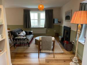 uma sala de estar com um sofá e uma cadeira em Isle of Skye luxury cottage near Portree em Kensaleyre
