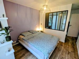 a bedroom with a bed and a potted plant at Cosy spacieux appartement balcon - Ourcq Paris 19 in Paris