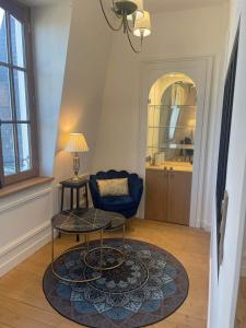 un soggiorno con tavolo e sedia blu di Le Royal XIX Dinard vue mer luxe a Dinard