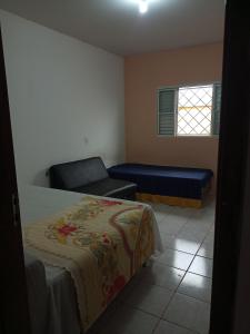 1 dormitorio con cama, sofá y ventana en QUARTO PRIVADO COM BANHEIRO, en Jaú