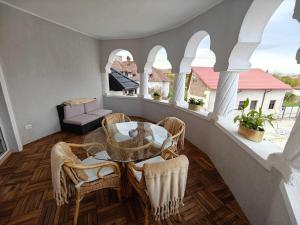 Habitación con balcón con mesa y sillas. en The Corner House, en Hunedoara