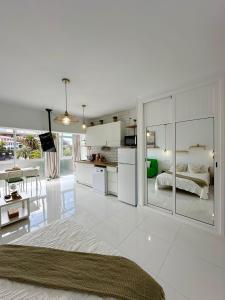 eine weiße Küche und ein Wohnzimmer mit einem Bett in der Unterkunft Paradise Studio Belair WiFi, piscina, parking in Puerto de la Cruz