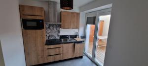 a small kitchen with a sink and a microwave at Maison DEOLS centre pour 1 a 2 personnes in Déols