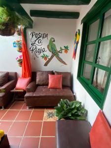 ein Wohnzimmer mit einem Sofa und einem Vogel an der Wand in der Unterkunft Posada La Rioja in Villa de Leyva