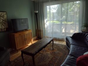 ein Wohnzimmer mit einem Sofa und einem Couchtisch aus Holz in der Unterkunft Montréal, Ahuntsic, 2 chambres, accueillant et charmant in Montreal