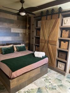 um quarto com uma cama grande e uma porta de madeira em Casa Apartamento Rural U Penafrol em Eljas