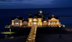 a large house with lights on a pier at night at Ferienwohnung Sellin in Ostseebad Sellin