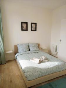 1 dormitorio con 1 cama con 2 cuadros en la pared en Vierzon (1) bel appart 4 pers, en Vierzon