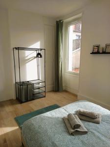 1 dormitorio con 1 cama con 2 toallas en Vierzon (1) bel appart 4 pers, en Vierzon