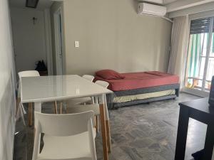 una habitación con una cama, una mesa y sillas en HERMOSO DEPTO. EN PLENO PALERMO SOHO, en Buenos Aires