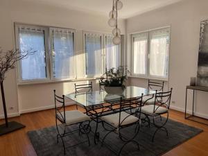 a dining room with a glass table and chairs at Le 40 in Sarreguemines