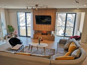 un soggiorno con un divano e un tavolo di Gudauri Travel Chalets in New Gudauri a Gudauri