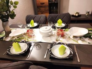 una mesa con platos blancos y servilletas. en Schöne 3 Zi. Ferienwohnung vor den Toren Frankfurt en Dreieich