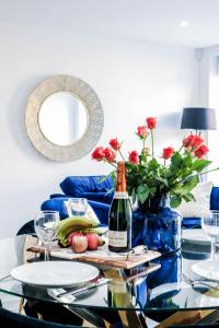un tavolo con una bottiglia di vino e un vaso con fiori di LUXURIOUS Apartments FREE parking and FREE WiFi! a Staines