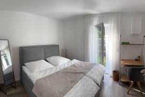 a bedroom with a bed and a desk and a window at Family Apart nähe Nürnberg in Schwaig bei Nürnberg