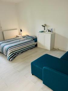 um quarto com uma cama e um sofá azul em Private Room Near Paris em Montreuil