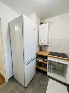 uma cozinha com um frigorífico branco e um balcão em Private Room Near Paris em Montreuil