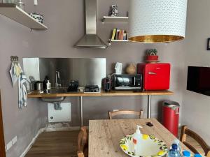 cocina con mesa, microondas y nevera en B&B La Mammola, en Lugo
