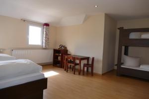 a bedroom with a desk and a bed and a table at Kulturhotel Kaiserhof in Bad Liebenstein