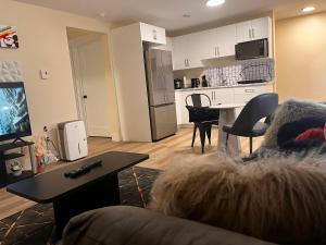 a living room with a couch and a table and a kitchen at Cozy Newly built apartment airport location in Dieppe