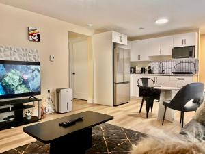 a living room with a television and a kitchen at Cozy Newly built apartment airport location in Dieppe